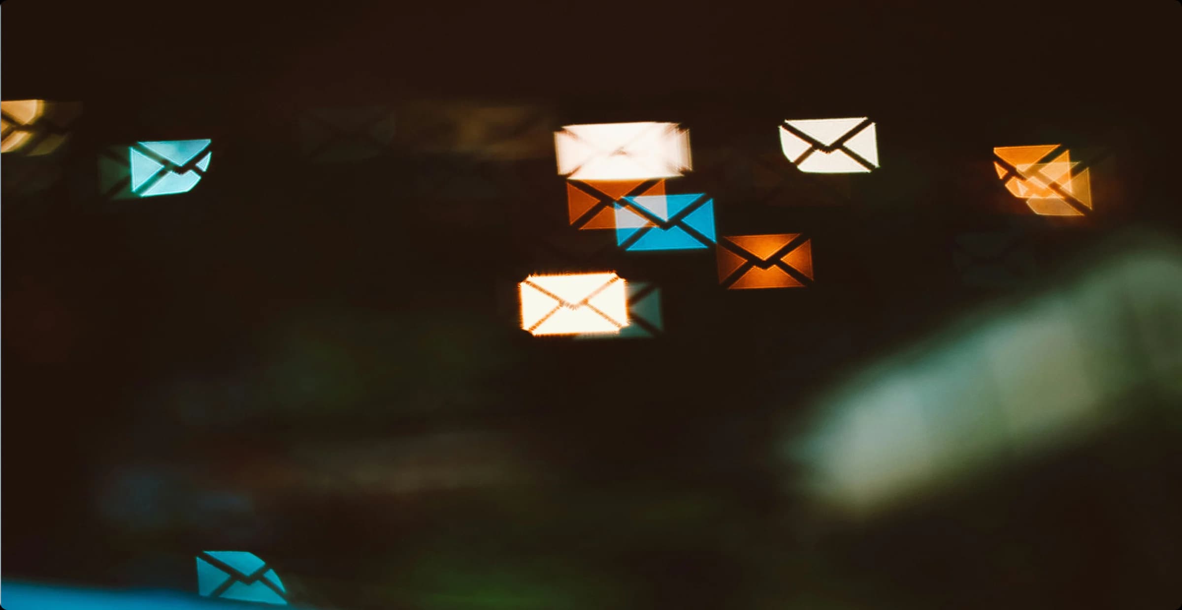 Dark photo of glowing envelope icons representing incoming sales order emails