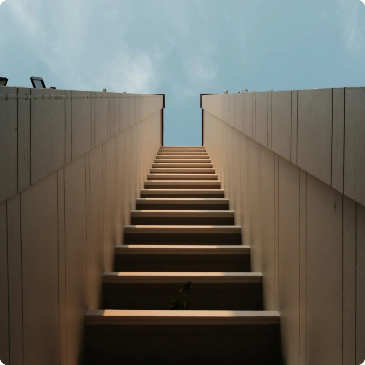 A concrete staircase rising toward open sky, illustrating the seven steps to autonomous SAP workflows