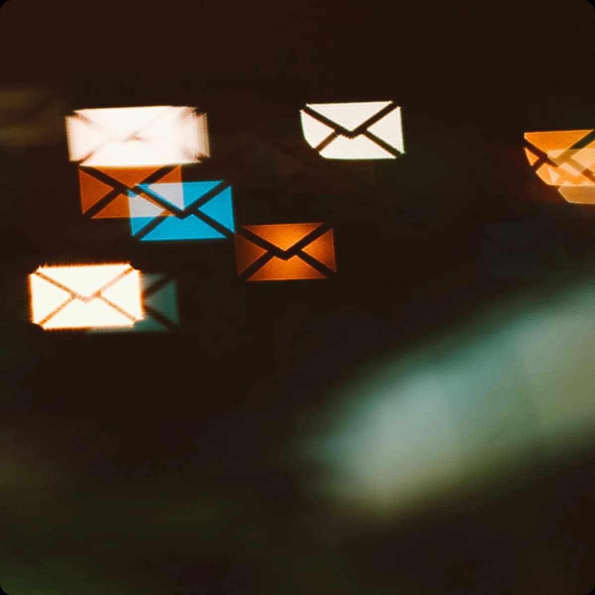 Dark photo of glowing envelope icons representing incoming sales order emails