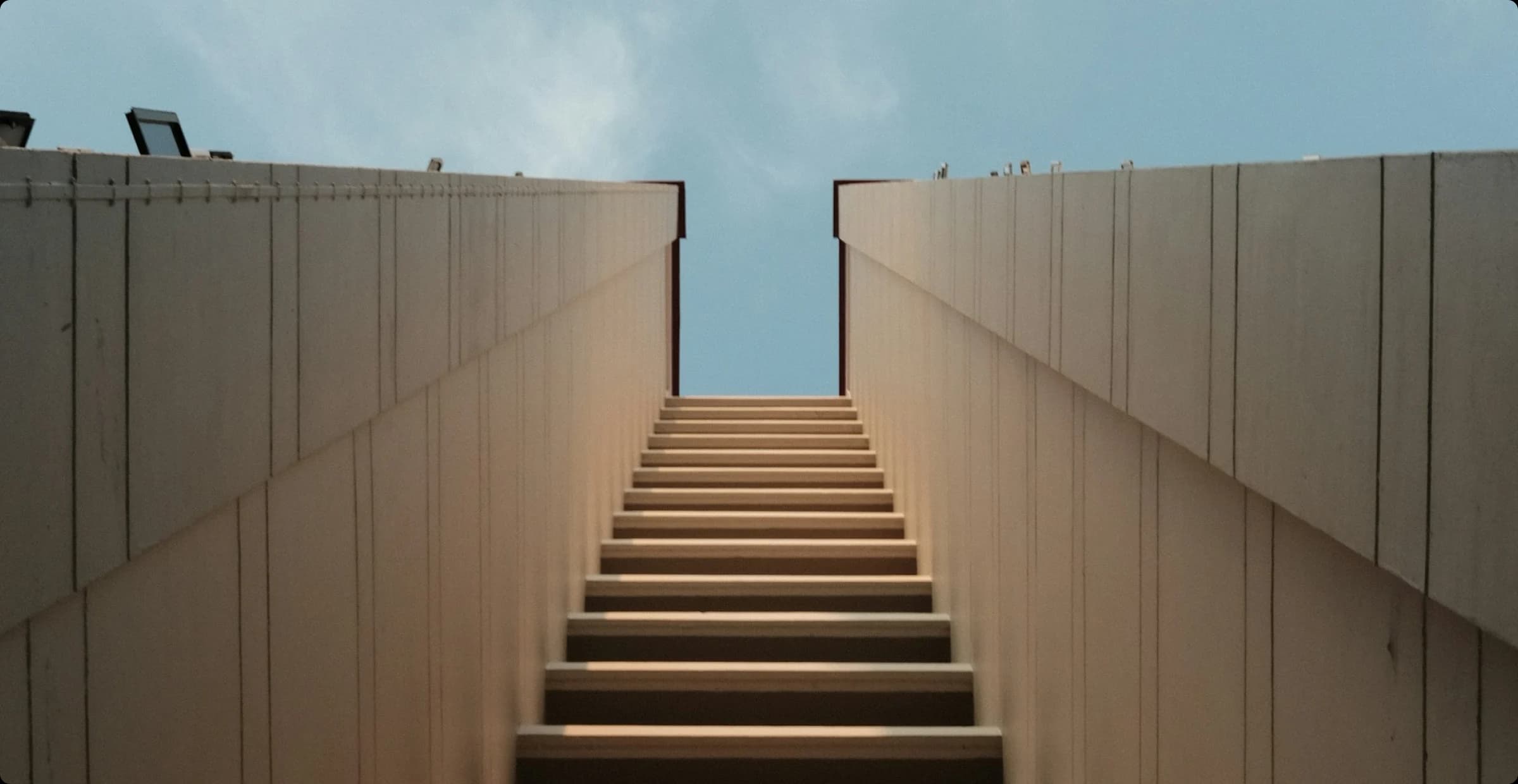 A concrete staircase rising toward open sky, illustrating the seven steps to autonomous SAP workflows